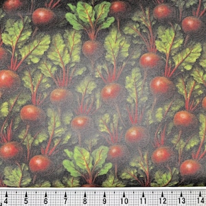 May include: Fabric with a repeating pattern of red beets with green leaves and red stems against a dark background. The beets are arranged in a dense, overlapping design, creating a textured appearance. The image includes a ruler at the bottom.