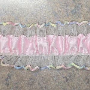 May include: Pink satin ribbon trim with white ruffled mesh and pastel colored edges.