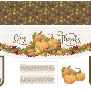 May include: A Thanksgiving table runner with a white background and a brown border. The runner features a garland of fall leaves and pumpkins with the words "Give Thanks" in the center.