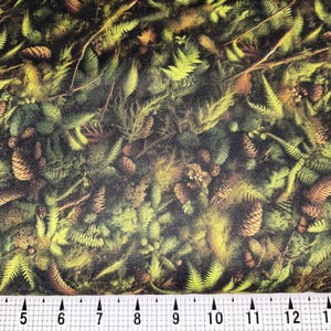 May include: Fabric with a forest-themed pattern. The design features a dense arrangement of green ferns, brown pinecones, and branches. The color palette includes shades of green, brown, and yellow, creating a naturalistic appearance. The fabric is suitable for various craft projects.