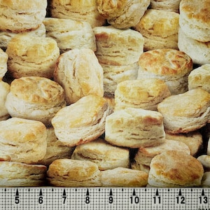 May include: A close-up image of a pile of golden brown biscuits. The biscuits are stacked on top of each other, creating a textured and inviting visual.