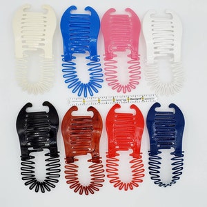 May include: Ten colorful plastic hair combs with a springy coil design. The combs are in various colors, including black, white, blue, pink, and red.