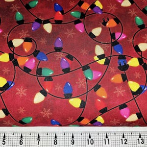 Pode incluir: Tecido vermelho com um padrão repetido de luzes de Natal coloridas e flocos de neve. As luzes são em várias cores, incluindo vermelho, laranja, amarelo, verde, azul e roxo, com fiação preta.