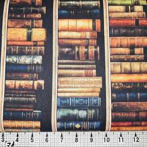 Puede incluir: Una tela negra con un patrón repetido de filas de libros en una estantería. Los libros son de varios colores y tamaños, algunos con letras doradas en los lomos.