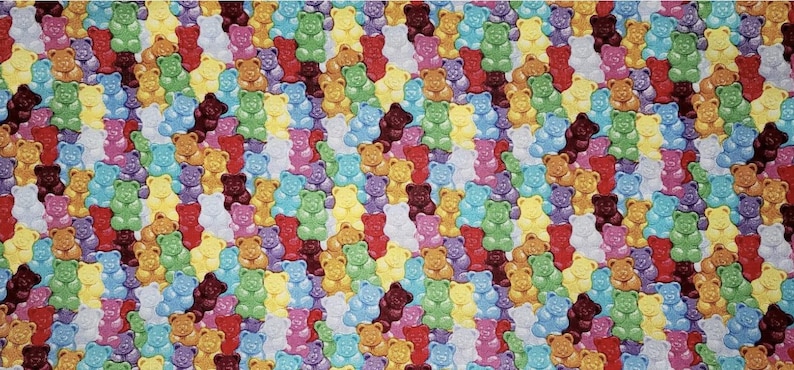 May include: A colorful pattern of gummy bears in various colors, including red, orange, yellow, green, blue, purple, and white. The gummy bears are arranged in a diagonal pattern.