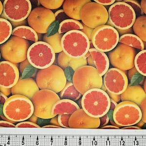 Può includere: Un motivo di tessuto con metà e frutti interi di pompelmo. L'immagine presenta la polpa rossa e succosa del pompelmo su uno sfondo di bucce gialle e arancioni, con foglie verdi sparse.