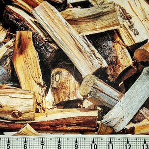 May include: A close-up of a pile of firewood, showing the different textures and colors of the wood. The wood is arranged in a random pattern, with some pieces stacked on top of others. The wood is dry and ready to be burned.