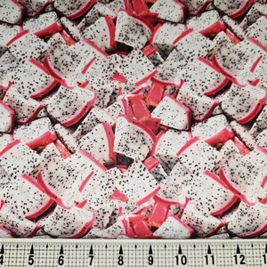 May include: Fabric with a repeating pattern of dragon fruit slices. The fruit pieces are white with black seeds and red edges and stems. The fabric is suitable for various sewing and crafting projects.