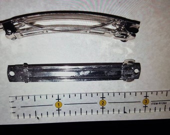 May include: Two silver hair clips, one curved and one straight, are shown on a white surface with a ruler marked in inches. The ruler is labeled "ITEM #1264".