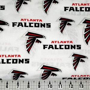 May include: White fabric with a repeating pattern of the Atlanta Falcons logo. The logo is a red and black bird with the words "Atlanta Falcons" printed below it.