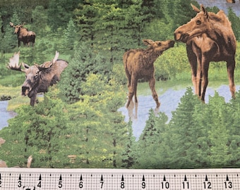 May include: A fabric with a repeating pattern of moose in a forest setting. The moose are brown and are standing in a green forest with blue water in the background.
