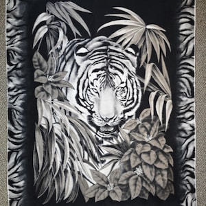May include: A black and white tiger blanket featuring a detailed tiger face surrounded by lush foliage. The blanket has a black border with a tiger stripe pattern. The design is printed on a soft, plush material.
