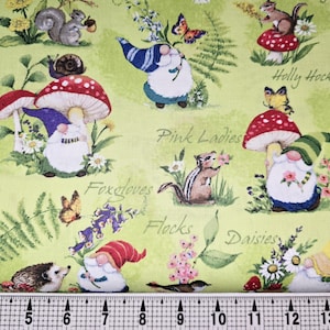 Pode incluir: Tecido com um padrão repetido de gnomos de jardim, cogumelos, borboletas, esquilos e flores sobre um fundo verde claro. As palavras "Holly Hock", "Pink Ladies", "Foxgloves", "Flocks" e "Daisies" estão escritas no tecido.