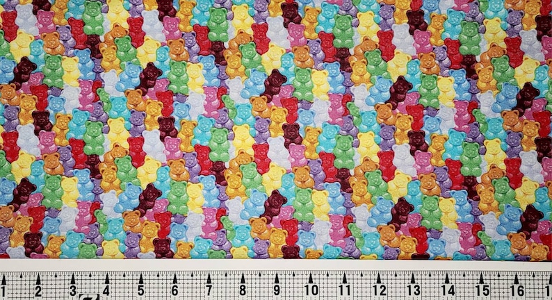 May include: A colorful fabric with a repeating pattern of gummy bears in various colors, including red, orange, yellow, green, blue, purple, and brown.