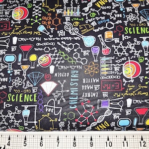 May include: Black fabric with a science-themed design. The fabric features colorful illustrations of chemistry and science elements, including molecules, beakers, and the words "Science" and "Chemistry". A ruler is at the bottom, with markings in inches.