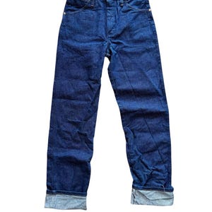 Op de afbeelding: Donkerblauwe jeans met een klassiek vijf-zakken ontwerp. De jeans hebben een knoopsluiting, riemlussen en zijn omgeslagen bij de enkels. De stof lijkt een medium-gewicht denim te zijn.