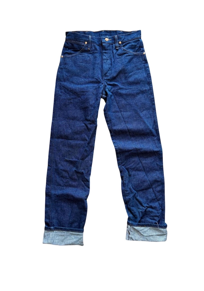 Op de afbeelding: Donkerblauwe jeans met een klassiek vijf-zakken ontwerp. De jeans hebben een knoopsluiting, riemlussen en zijn omgeslagen bij de enkels. De stof lijkt een medium-gewicht denim te zijn.