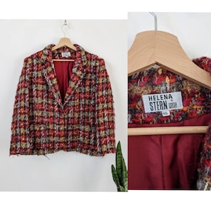 May include: A red, black, and gold tweed blazer with a red satin lining. The blazer has a single button closure and a label that reads "HELENA STERN PARIS 46".