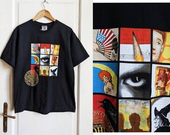 Könnte beinhalten: Schwarzes T-Shirt mit einer Collage von Bildern, darunter eine Nahaufnahme eines Auges, ein Rabe und eine Frau mit roten Haaren. Der Text "Sondheim Celebration" ist auf dem T-Shirt aufgedruckt.