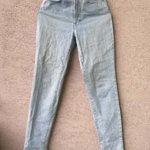 K&ouml;nnte beinhalten: Hellblaue Jeans aus Denim mit hohem Bund. Die Jeans haben ein klassisches F&uuml;nf-Taschen-Design und ein gerades Bein. Die Jeans h&auml;ngen an einem Metallb&uuml;gel. Der Denim hat eine verwaschene Optik.