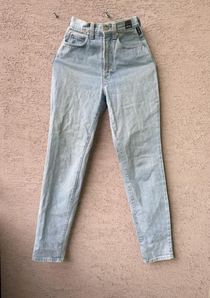 K&ouml;nnte beinhalten: Hellblaue Jeans aus Denim mit hohem Bund. Die Jeans haben ein klassisches F&uuml;nf-Taschen-Design und ein gerades Bein. Die Jeans h&auml;ngen an einem Metallb&uuml;gel. Der Denim hat eine verwaschene Optik.