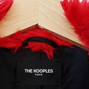 Puede incluir: Una chaqueta de piel sint&eacute;tica roja con una etiqueta negra que dice "THE KOOPLES PARIS".