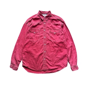 Op de afbeelding: Een rood shirt met lange mouwen met een knoopsluiting en twee borstzakken. Het shirt heeft een klassieke westernstijl met puntige kleppen en parelmoer drukknopen. De stof lijkt een gewassen denim te zijn.
