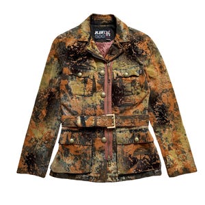 May include: A long-sleeve jacket featuring a mottled, multi-colored pattern in shades of brown, orange, and dark green. The jacket includes a front zipper, a waist belt with a metal buckle, four front pockets with gold-tone buttons, and a collar.