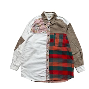 May include: A patchwork button-down shirt with a unique design. The shirt features a mix of fabrics, including white, brown, floral, and plaid patterns. It has long sleeves and a collared neckline, offering a vintage aesthetic.