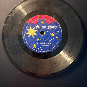 May include: A vintage 45 RPM vinyl record from Little John Records, featuring the song "Silent Night." The record label is blue with gold stars and a yellow starburst. The text includes "MOHR-1818" and "Made in U.S.A."