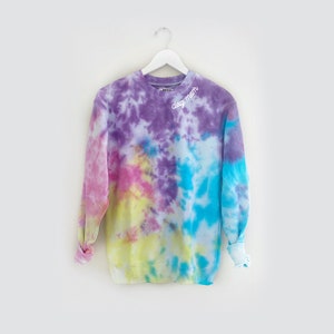 May include: A tie-dye long-sleeve sweatshirt with the text "daydream" in white lettering on the front.