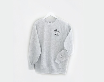 LOVE U MORE <3 an embroidered fleece pullover sweatshirt with a heart on the sleeve