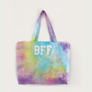 May include: A tie-dye tote bag with white letters that spell "BFF" on the front.
