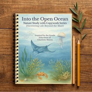 Pode incluir: Um caderno espiralado intitulado "Into the Open Ocean" com uma ilustração com tema oceânico. A capa apresenta uma arraia, uma água-viva e um caranguejo. Dois lápis e um raminho de vegetação estão ao lado do caderno sobre uma superfície de madeira.