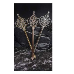 May include: Three ornate jeweled scepters with gold, silver, and rose gold finishes. The scepters have a crown-like top with intricate details and are made of plastic.