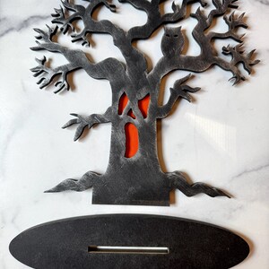 Pu&ograve; includere: Decorazione a tema Halloween a forma di albero spettrale con finitura grigia anticata, con un gufo e un volto intagliato con sfondo arancione. Include una base ovale nera separata con una fessura per l'esposizione. Perfetto per Halloween.