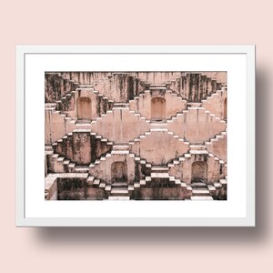 May include: A photograph of a symmetrical, geometric structure made of stone. The structure is a series of steps that lead up to a series of arches. The steps are made of a light brown stone, and the arches are made of a darker brown stone.