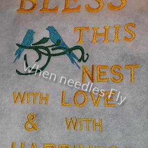 Peut inclure: Broderie représentant deux oiseaux bleus sur une branche, avec le texte "Bless this nest with love & with happiness".
