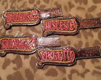 En el conjunto de bordado de la máquina del aro de signos del zodíaco llaveros