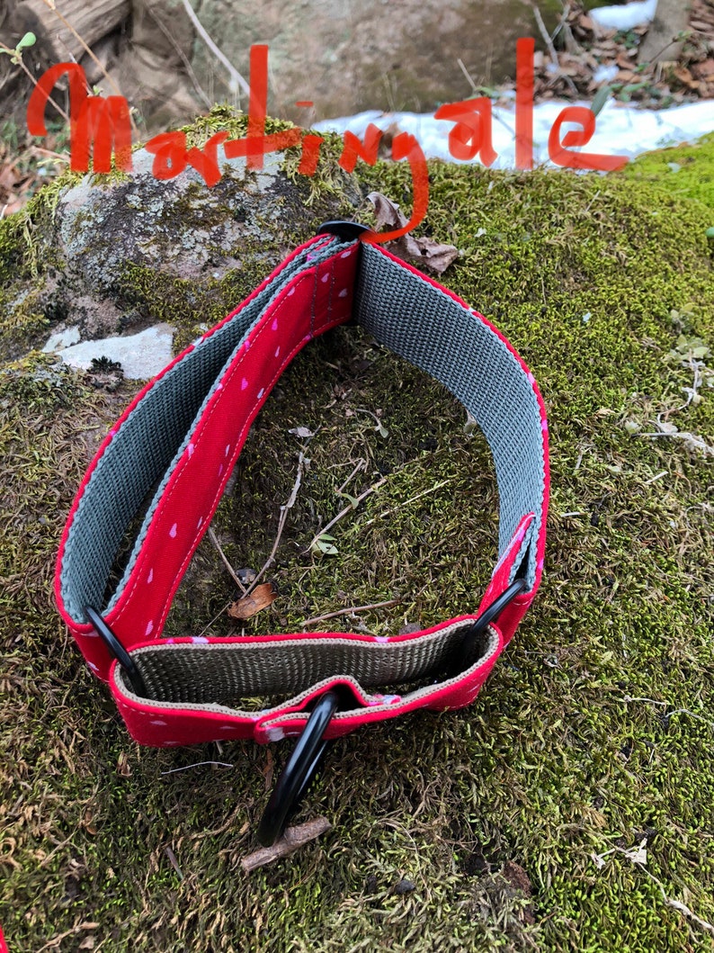 May include: A red martingale dog collar with a pattern of small pink hearts. The collar has a gray interior and black metal hardware. The word "Martingale" is written in red on the top of the image.