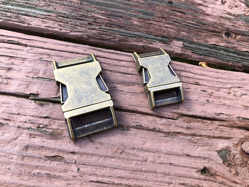 May include: Two antique gold-toned metal slider buckles. The buckles are rectangular with a smooth, slightly textured surface.