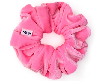 May include: A pink velvet scrunchie with a white label that says "NEON" on it.