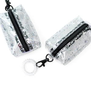 Estuche pequeño con diseño de estrellas holográficas y brillantes, con llavero y correa de muñeca, vinilo transparente.