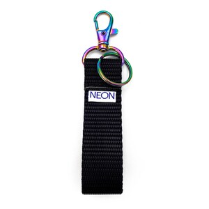 May include: A black key chain with a rainbow colored metal clip and a small metal ring. The key chain has a white label with the word "NEON" printed in blue.