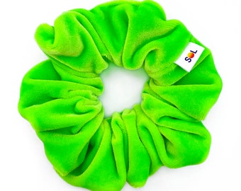 May include: A bright green velvet scrunchie with a small white label that says "SOL" in black text.