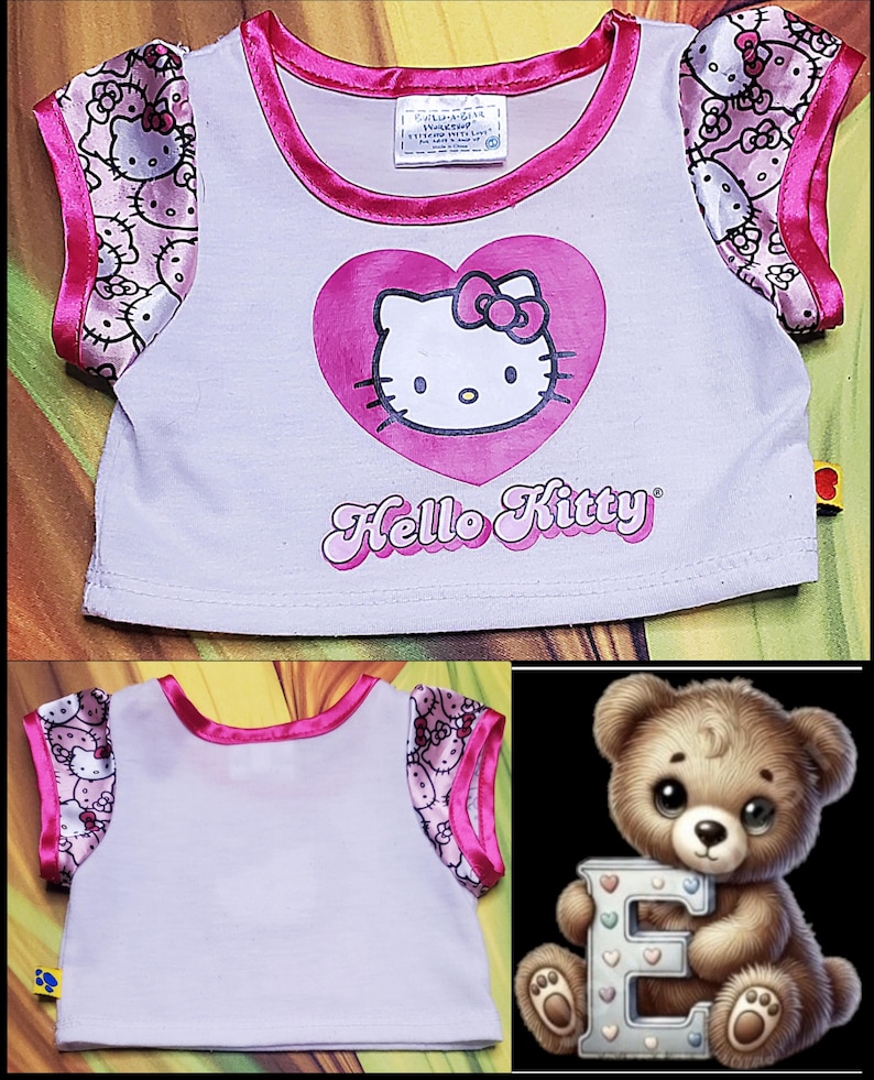 Może przedstawiać: Biała koszulka Hello Kitty z r&oacute;żowymi wykończeniami i rękawami. Koszulka posiada duże r&oacute;żowe serce z twarzą Hello Kitty i napisem "Hello Kitty" w kursywie. Rękawy mają wz&oacute;r Hello Kitty.
