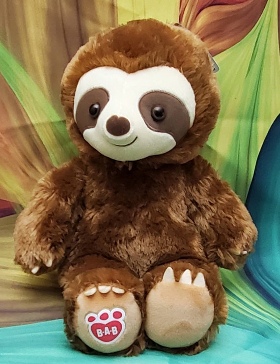 baby sloth hugging stuffed animal