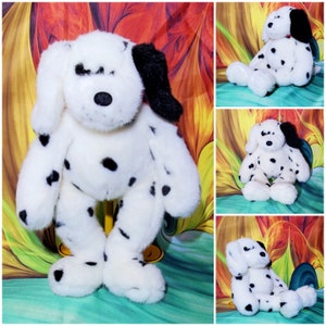 May include: A plush Dalmatian dog toy with white fur and black spots. The dog has floppy ears, a black nose, and is in a sitting position. The toy is soft and cuddly, perfect for children.
