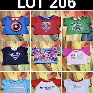 May include: A collection of nine colorful children's t-shirts. The shirts feature various designs, including superhero logos, cartoon characters, and text. The shirts are in various colors, including blue, red, green, and pink. The text "LOT 206" is at the top.