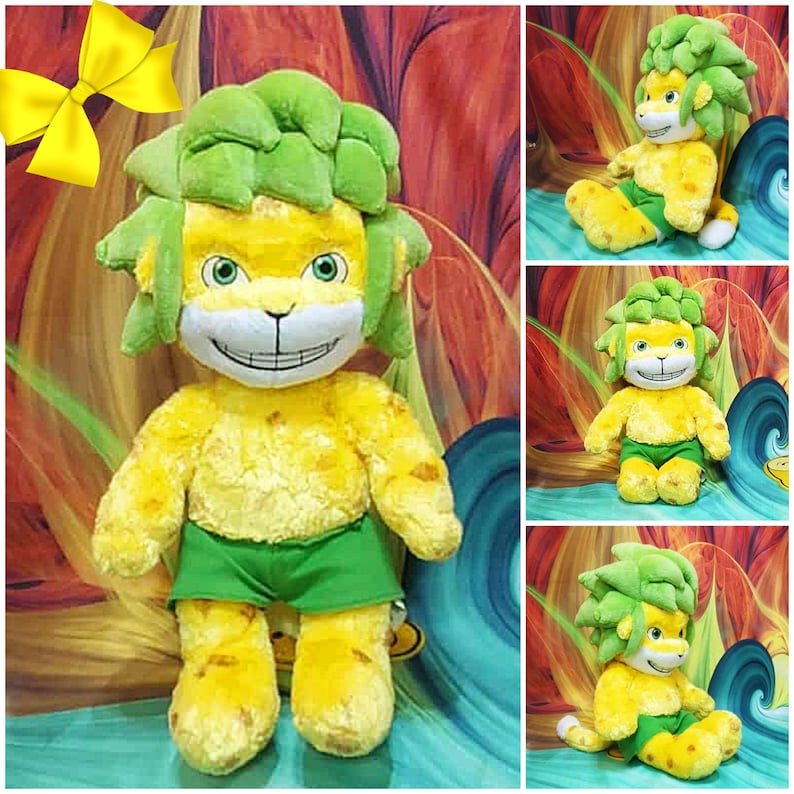 May include: A plush toy lion with yellow fur, green hair, and green shorts. The lion has a smiling face with a white muzzle and a green and yellow mane. The toy is in multiple poses, including sitting and standing.